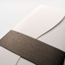 Λεπτομέρεια χαρτιού πρόσκλησης σε λείο λευκό με μεταλλιζέ γραμμές και φάσας σε καφέ μεταλλιζέ χαρτί_Κωδικός 5824