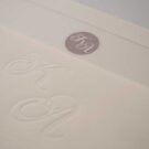 Προσκλητήριο Γάμου: Λεπτομέρεια εκτύπωσης μονογράμματα βαθυτυπία (letterpress) σε φάκελο γραμμωτό ζαχαρί και λεπτομέρεια κάρτας με γκοφρέ πλαίσιο_Κωδικός 5964