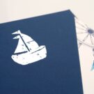 Λεπτομέρεια_Προσκλητήριο Βάπτισης: Φάκελος διάστασης 16,8x16,8 εκατ. σε χαρτί γκοφρέ (ανάγλυφο) γραμμωτό navy blue (ναυτικό μπλε) 160 γραμ. με ασημοτυπία καράβι και Κάρτα σε χαρτί γκοφρέ γραμμωτό (ανάγλυφο) υπόλευκο 250 γραμ. με εκτύπωση μίας όψης μελάνι σε χρώμα ναυτικό μπλε, κόκκινο, καφέ και γκρι με θέμα πηδάλιο, καράβι, άγκυρα, ναυτικό σκοινί_Κωδικός 50823