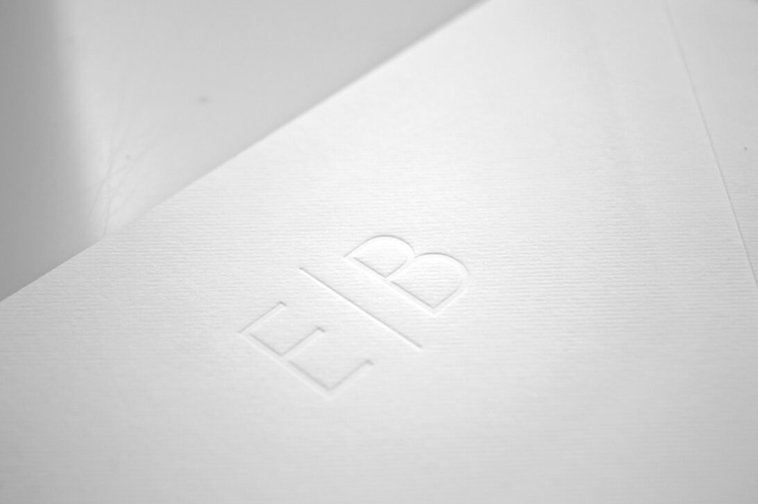 Προσκλητήριο Γάμου: Λεπτομέρεια μονογράμματα βαθυτυπία (letterpress) χωρίς χρώμα σε Φάκελο γραμμωτό υπόλευκο_Κωδικός 5955