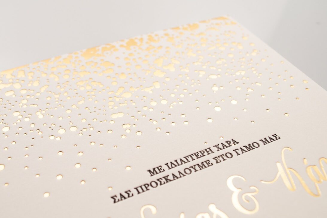 Λεπτομέρεια Προσκλητήριο Γάμου: Κάρτα βαμβακερή λευκή 1000 γραμ. με εκτύπωση βαθυτυπία (letterpress) σε χρώμα μαύρο (μαυροτυπία) και χρυσό (χρυσοτυπία) και θέμα χρυσή βροχή από δάκρυα και χρυσά polka dots_Κωδικός 6105