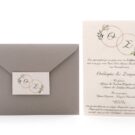 Προσκλητήριο Γάμου: Φάκελος διάστασης 13,3x18,3 εκατ. σε χαρτί οικολογικό με άγρια υφή γκρι 160 γραμ., καρτάκι 4x6,5 εκατ. και Κάρτα σε χαρτί γκοφρέ (ανάγλυφο) μπιμπικωτό λευκό 250γραμ. με εκτύπωση μελάνι γκρι και λαδί και θέμα βέρες και λουλούδια_Κωδικός 6128