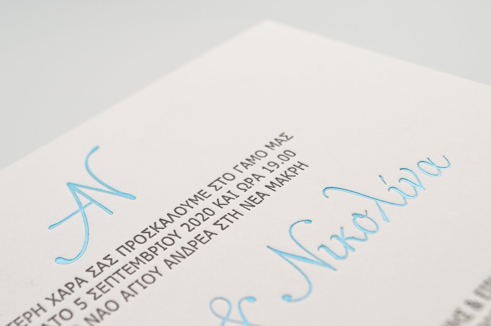 Κάρτα από βαμβακόχαρτο με λεπτομέρεια κειμένου και μονογράμματος με εκτύπωση βαθυτυπία (letterpress) και θερμοτυπία (foil) γκρι και γαλάζιο