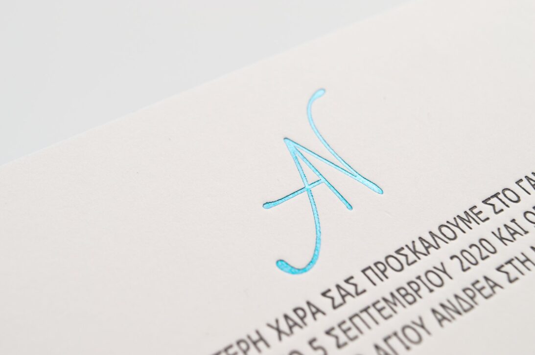 Κάρτα από βαμβακόχαρτο με λεπτομέρεια κειμένου και μονογράμματος με εκτύπωση βαθυτυπία (letterpress) και θερμοτυπία (foil) γκρι και γαλάζιο