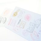 Λεπτομέρεια Προσκλητηρίου Βάπτισης: Δίπτυχο διαβατήριο διάστασης 11x15,5 εκατ. – Εσώφυλλο σε χαρτί λείο ματ λευκό 150 γραμ. με εκτύπωση δύο όψεων μελάνι με θέμα σφραγίδες χωρών (α΄ όψη)