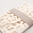 Λεπτομέρεια Φάκελος τρίπτυχος τρυπητός Lasercut 12,2 x 21,5 εκατ. μεταλλιζέ υπόλευκος και Κάρτα μεταλλιζέ υπόλευκη με φάσα λαμιναριστή λιλά 3,5x13 εκατ.