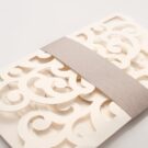 Λεπτομέρεια Φάκελος τρίπτυχος τρυπητός Lasercut 12,2 x 21,5 εκατ. μεταλλιζέ υπόλευκος και Κάρτα μεταλλιζέ υπόλευκη με φάσα λαμιναριστή λιλά 3,5x13 εκατ.