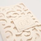 Λεπτομέρεια Φάκελος τρίπτυχος τρυπητός Lasercut 12,2 x 21,5 εκατ. μεταλλιζέ υπόλευκος και Κάρτα μεταλλιζέ υπόλευκη με καρτάκι 5x6 εκατ.