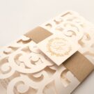 Λεπτομέρεια Φάκελος τρίπτυχος τρυπητός Lasercut 12,2 x 21,5 εκατ. μεταλλιζέ υπόλευκος και Κάρτα μεταλλιζέ υπόλευκη με φάσα λαμιναριστή χρυσή 3,5x13 εκατ. και καρτάκι 5x5 εκατ.