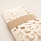 Λεπτομέρεια Φάκελος τρίπτυχος τρυπητός Lasercut 12,2 x 21,5 εκατ. μεταλλιζέ υπόλευκος και Κάρτα μεταλλιζέ υπόλευκη με φάσα λαμιναριστή χρυσή 3,5x13 εκατ.