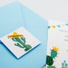 Προσκλητήριο Βάπτισης: Φάκελος διάστασης 16,8x16,8 εκατ. σε χαρτί λείο σιελ 150 γραμ. με καρτάκι 5x5 εκατ. με θέμα κάκτο και μεξικάνικο καπέλο (σομπρέρο) και Κάρτα σε χαρτί γκοφρέ (ανάγλυφο) μπιμπικωτό λευκό 250 γραμ., με εκτύπωση μίας όψης και θέμα λάμα, κάκτος, σημαιάκια_Κωδικός 50854