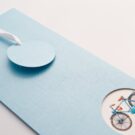 Λεπτομέρεια Προσκλητηρίου Βάπτισης: Φάκελος τραβηχτός ορθογώνιος σε χαρτί δερματίνη (σχέδιο οριζόντιες και κάθετες γραμμές) σιελ 380 γραμ. και Κάρτα με θέμα ποδήλατο_Κωδικός 50678