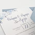 Λεπτομέρεια Προσκλητηρίου Γάμου και Βάπτισης: Φάκελος διάστασης 16x22 εκατ. σε χαρτί οικολογικό (άγρα υφή) βρώμικο γαλάζιο 160 γραμ., και Κάρτα σε χαρτί γκοφρέ (μπιμπικωτό) λευκό 250 γραμ. με εκτύπωση μελάνι και θέμα λουλούδια και γεωμετρικό πλαίσιο ασημοτυπία_Κωδικός ΓΒΝΣ 2014