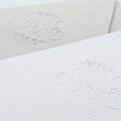 Λεπτομέρεια Προσκλητηρίου Γάμου: Φάκελος διάστασης 16x22 εκατ. σε χαρτί γκοφρέ γραμμωτό γκρι 160γραμ. με μονογράμματα και κλαδιά σε γκοφρέ εκτύπωση και Κάρτα σε χαρτί γκοφρέ γραμμωτό υπόλευκο 250 γραμ. με μονογράμματα και κλαδιά σε γκοφρέ εκτύπωση και κείμενο με εκτύπωση μελάνι γκρι_Κωδικός ΓΝΣ 3002