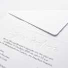 Λεπτομέρεια Προσκλητηρίου Γάμου: Φάκελος διάστασης 16,8x16,8 εκατ. σε χαρτί γκοφρέ γραμμωτό 160γραμ. υπόλευκο με εκτύπωση μονογραμμάτων σε χρυσοτυπία γυαλιστερή και Κάρτα σε χαρτί γκοφρέ γραμμωτό 250 γραμ. υπόλευκο με γκοφρέ πλαίσιο και με εκτύπωση κειμένου μελάνι γκρι και χρυσό_Κωδικός ΓΝΣ 3040